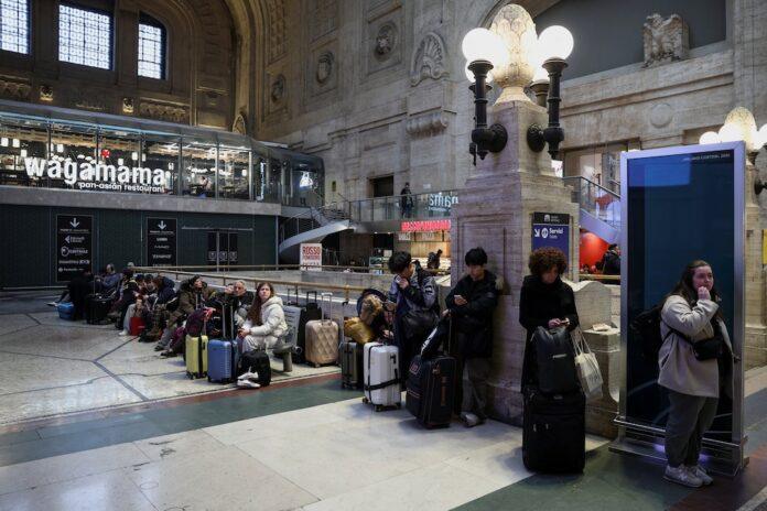 People wait at Milan train station, as Italian police investigate possible sabotage to power cables near the city of Bologna, which has caused delays across much of the national rail network (REUTERS/Guglielmo Mangiapane)